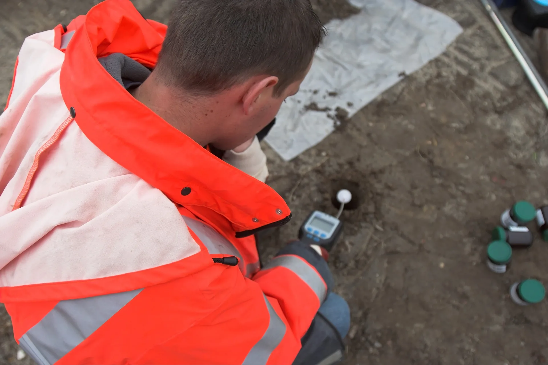 ESA consultant using a soil probe during site investigation