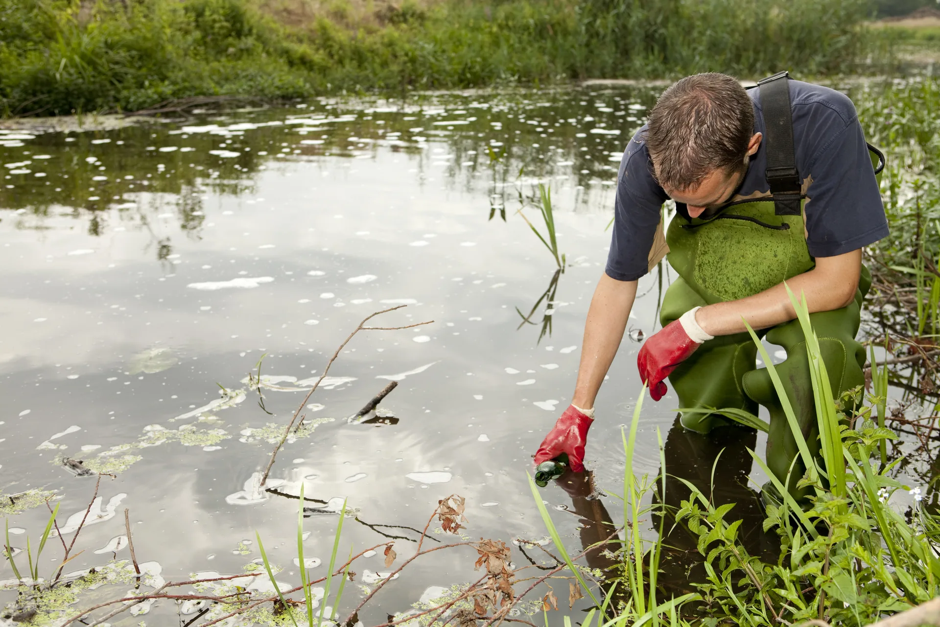 Environmental consultant collecting water samples for analysis